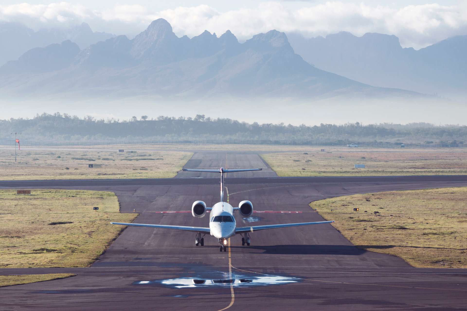 Passenger jet on runway with mountain and fog in the background, pilot training concept
